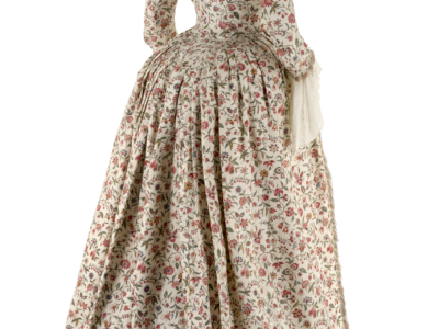 Robe vintage du XVIIIe siècle, au corsage ajusté et à la jupe ample et longue, en tissu blanc orné d'un motif floral rouge et vert, exposée au musée de la Toile de Jouy sur fond blanc. - Musée de la Toile de Jouy