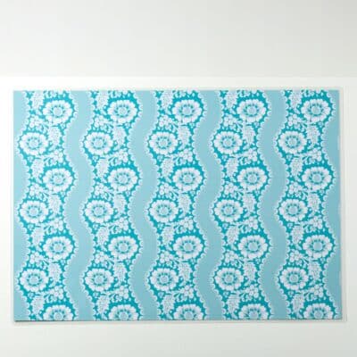 SET DE TABLE PLASTIFIE "FLEURS STYLISEES SUR MONTANTS ONDULANTS" BLEU LAGON